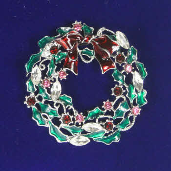 A pretty, christmas wreath with red bow, green leaves and coloured stones